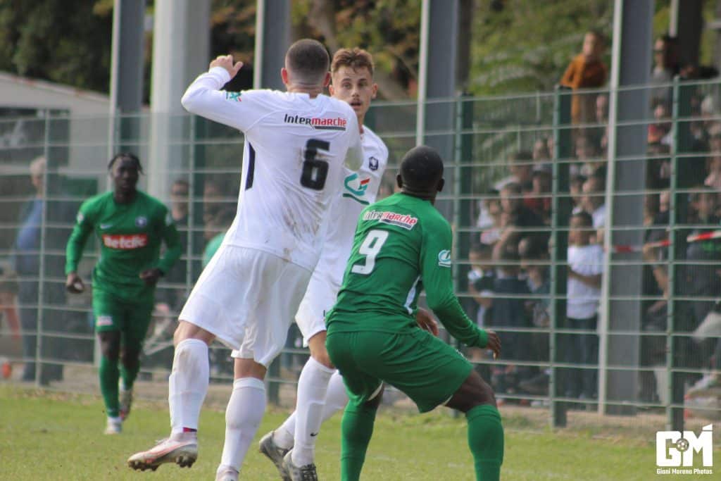 Dzabana au duel avec un défenseur adverse en Coupe de France